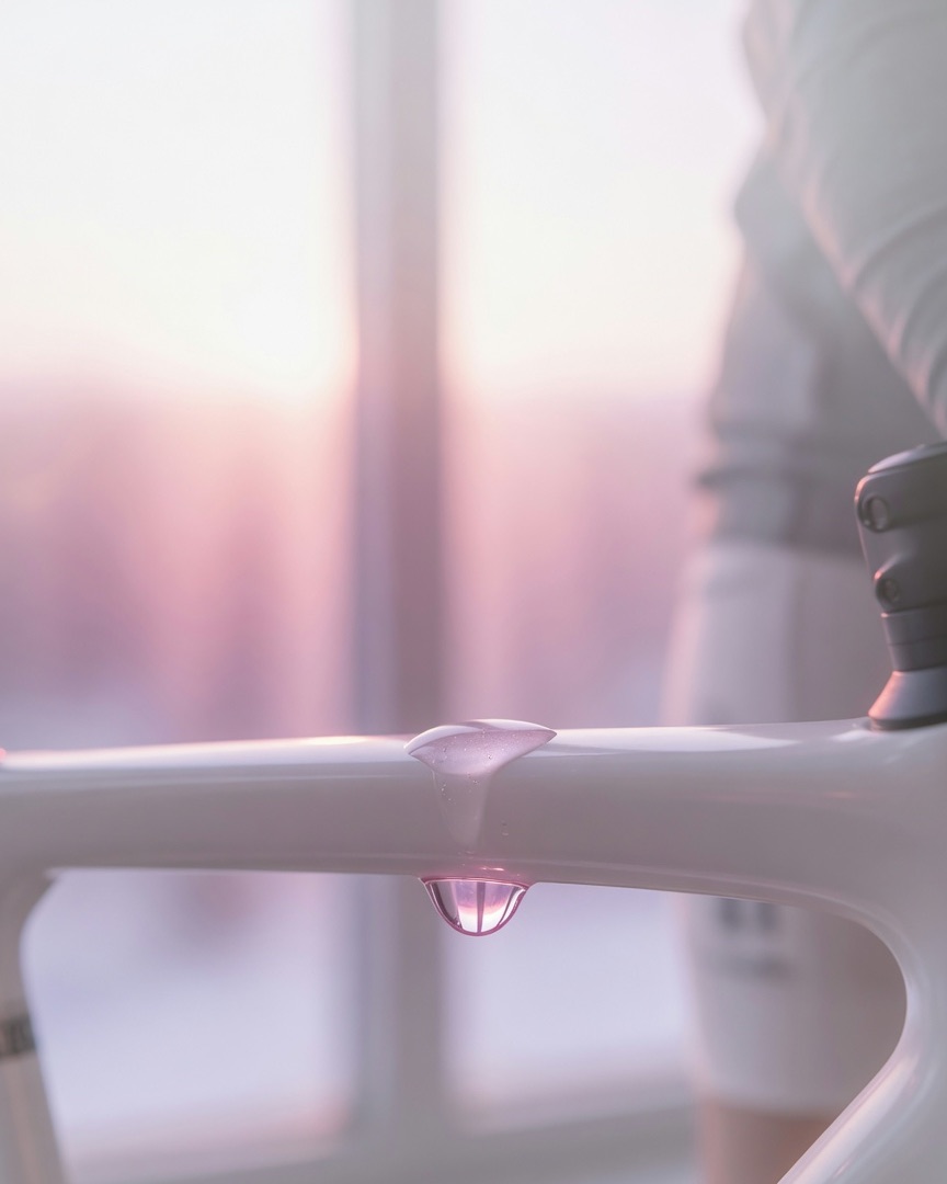 A drop of sweat on the top tube, backlit by the dawn window.